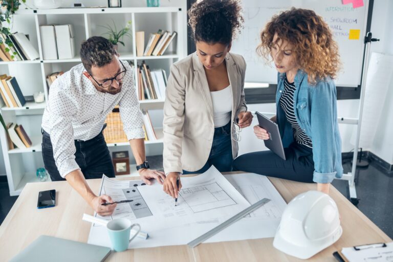 smart-architects-working-with-plans-while-talking-of-their-new-design-business-in-the-office-